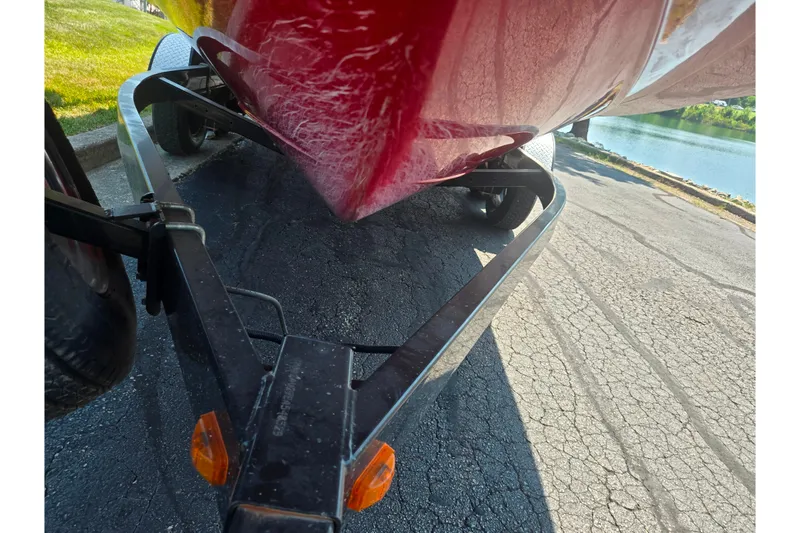 Slide: The Image of 2014 Yamaha Boats 242 Limited S on trailer by a lakeside road. - 7