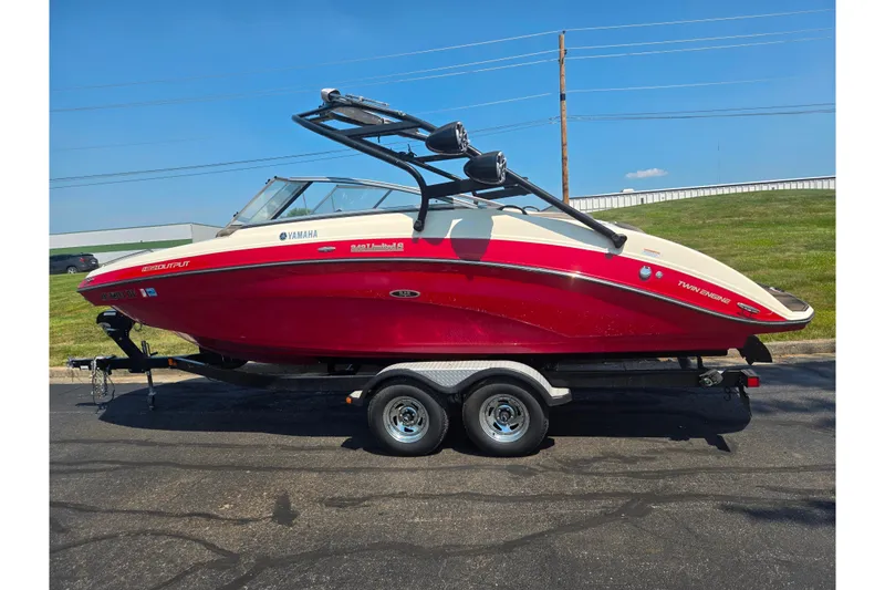 Slide: The Image of 2014 Yamaha Boats 242 Limited S in red on trailer, parked outdoors. - 4