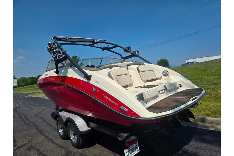 Slide: The Image of 2014 Yamaha Boats 242 Limited S in red, parked on a trailer, rear view. - 3