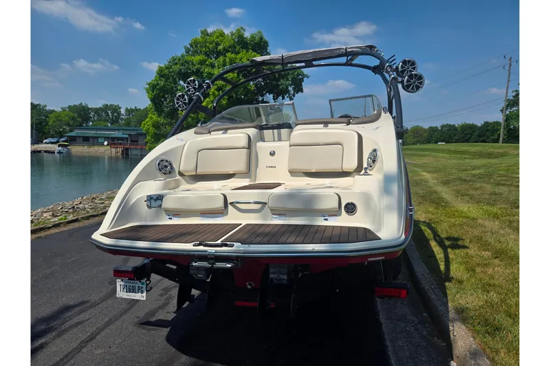 Slide: The Image of 2014 Yamaha Boats 242 Limited S on trailer, rear view by a lakeside. - 2