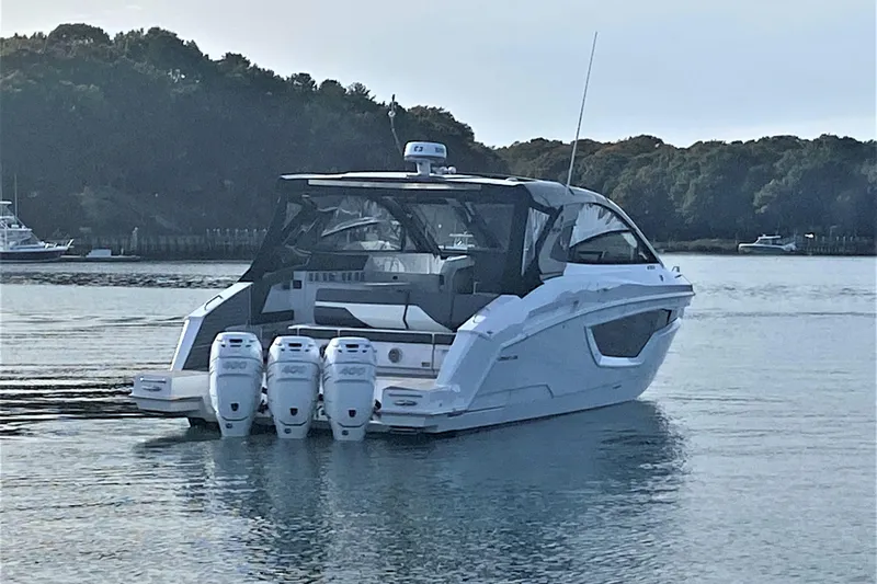 Slide: The Image of 2026 Cruisers Yachts 42 GLS OB on serene water with triple outboard engines. - 7