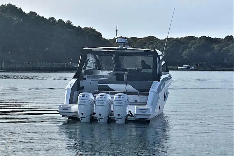 Slide: The Image of 2026 Cruisers Yachts 42 GLS OB with triple outboard engines on calm water. - 8