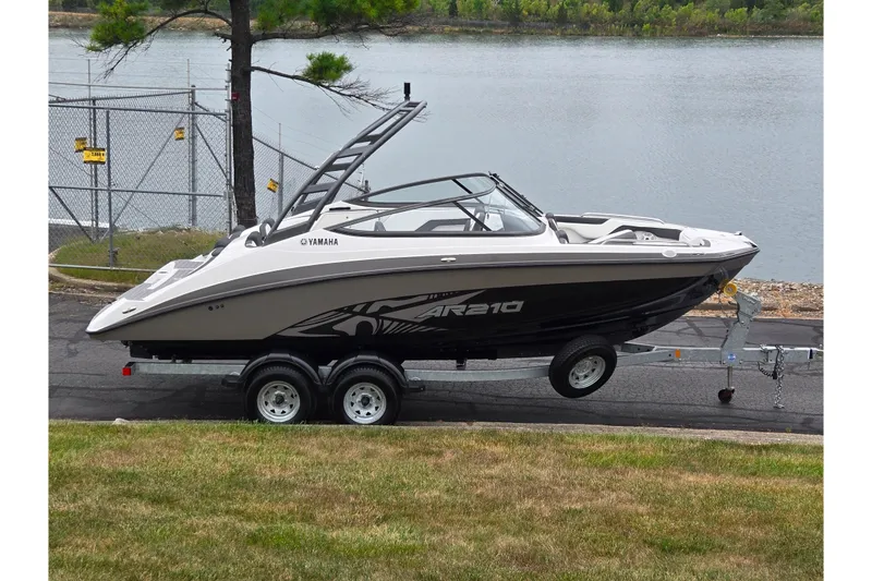 The Image of 2022 Yamaha Boats AR210 on trailer by a lakeside, ready for adventure. - 0