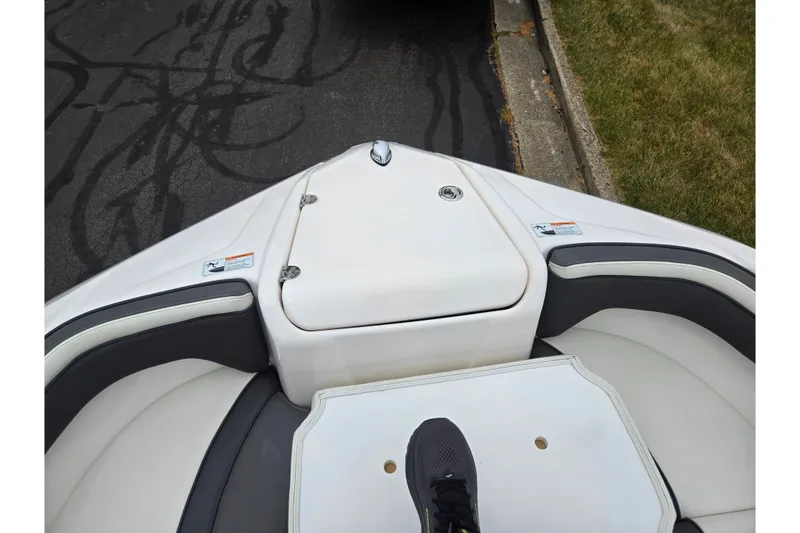 Slide: The Image of Bow seating area of a 2022 Yamaha AR210 boat with white and gray upholstery. - 17