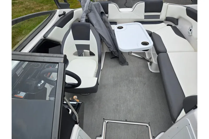 Slide: The Image of 2022 Yamaha Boats AR210 interior with seating, table, and steering wheel. - 20