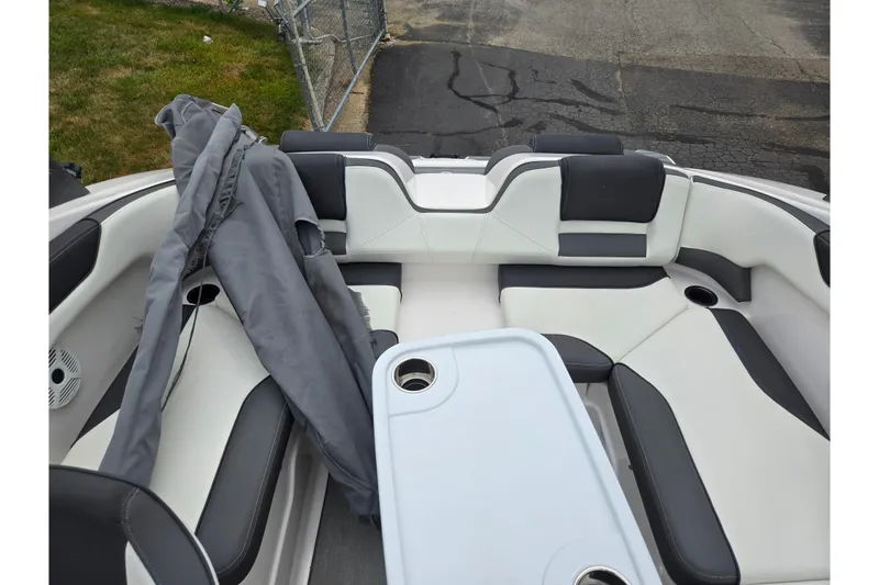 Slide: The Image of 2022 Yamaha Boats AR210 interior with seating and table, featuring sleek black and white design. - 21
