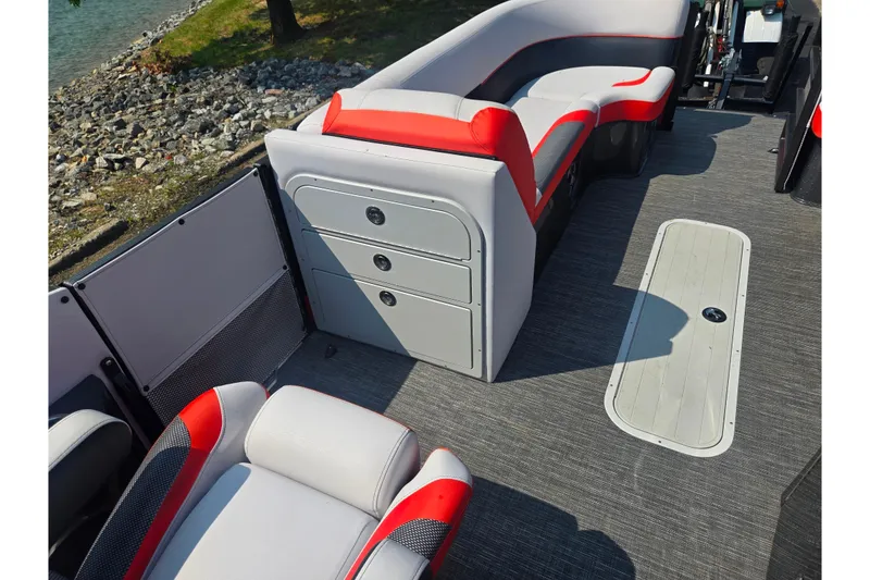 Slide: The Image of 2023 Crest Caribbean RS 230 boat interior with red and gray seating near a rocky shoreline. - 15