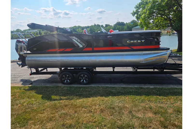 Slide: The Image of 2023 Crest Caribbean RS 230 pontoon boat on trailer by a lake. - 9