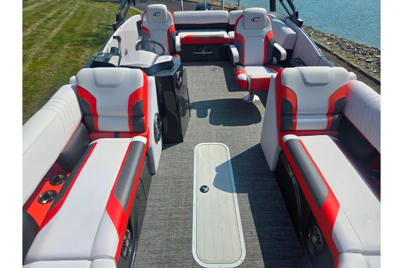 Slide: The Image of 2023 Crest Caribbean RS 230 boat interior with red and gray seating, near water. - 20