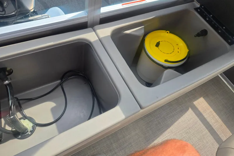 Slide: The Image of Storage compartments on a 2023 Sun Tracker SportFish 22 DLX boat, featuring a yellow-lidded container. - 20
