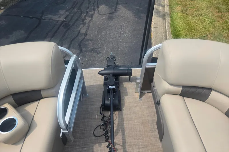 Slide: The Image of 2023 Sun Tracker SportFish 22 DLX boat interior with beige seating and trolling motor. - 27