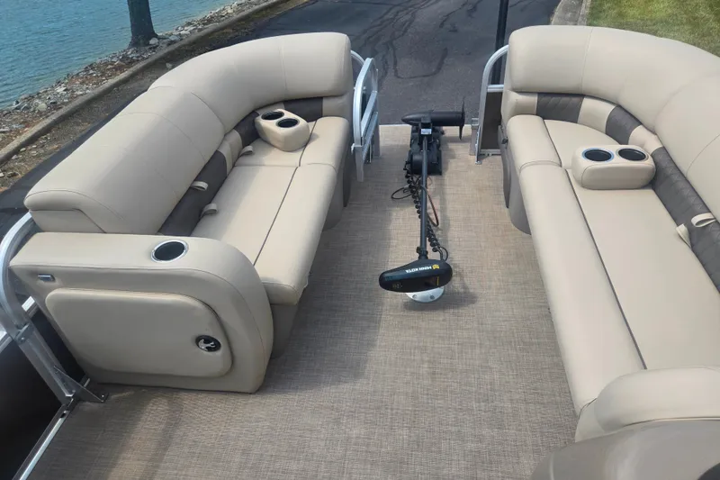Slide: The Image of 2023 Sun Tracker SportFish 22 DLX pontoon boat interior with beige seating and cup holders. - 25