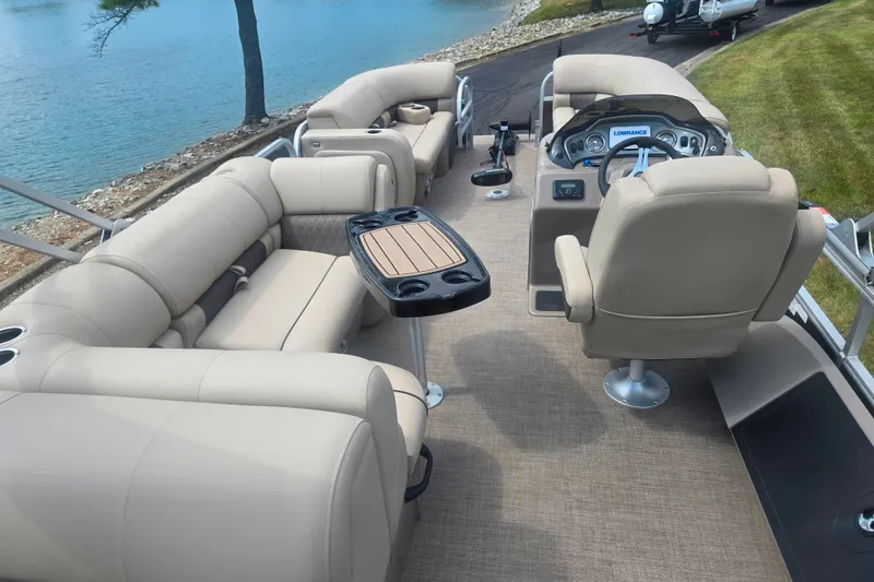 Slide: The Image of 2023 Sun Tracker SportFish 22 DLX pontoon boat interior with beige seating and steering console. - 21