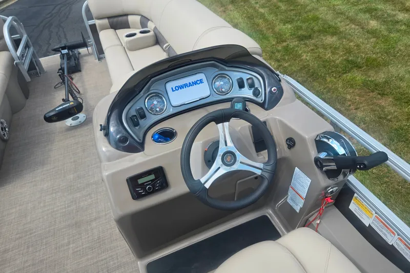 Slide: The Image of 2023 Sun Tracker SportFish 22 DLX boat dashboard with steering wheel and Lowrance display. - 23