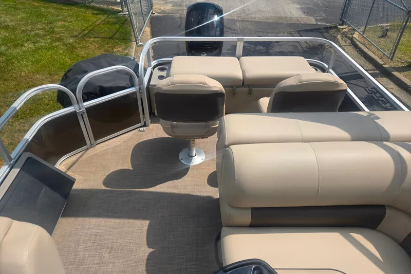 Slide: The Image of 2023 Sun Tracker SportFish 22 DLX pontoon boat interior with beige seating and helm. - 15