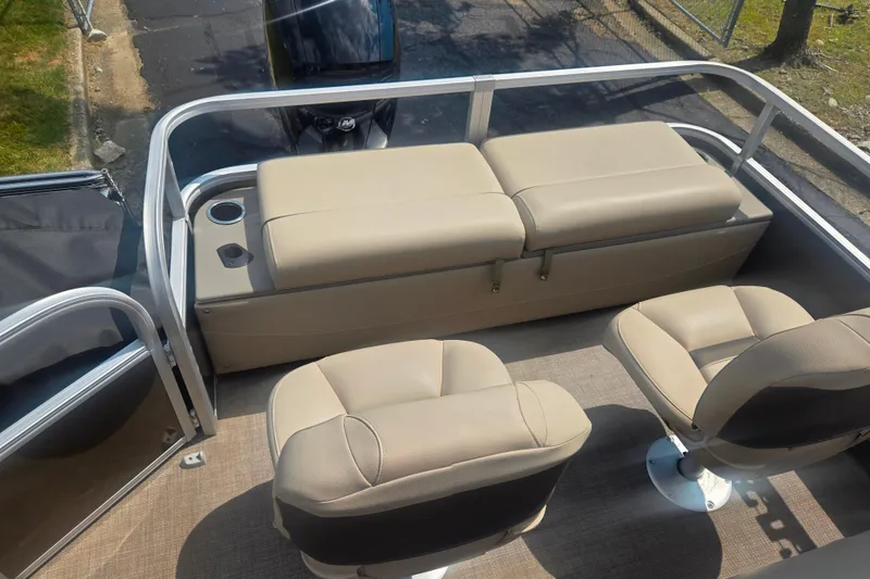 Slide: The Image of 2023 Sun Tracker SportFish 22 DLX boat interior with beige seating and cup holders. - 18