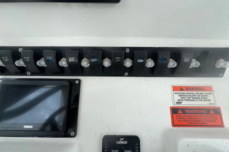 Slide: The Image of Control panel of a 2015 Sea Hunt Ultra 235SE boat with switches and warnings. - 20