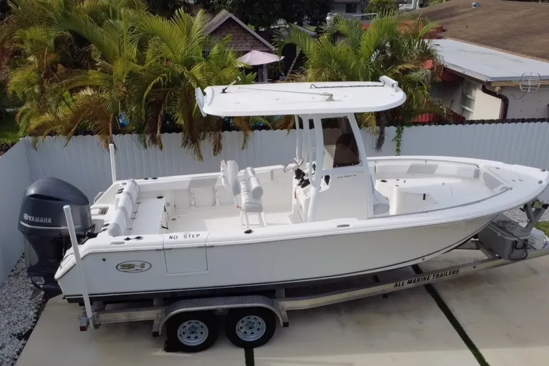 The Image of 2015 Sea Hunt Ultra 235SE boat on trailer, surrounded by palm trees. - 0