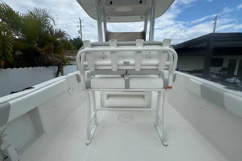 Slide: The Image of 2015 Sea Hunt Ultra 235SE boat interior with seating and console, under a partly cloudy sky. - 16