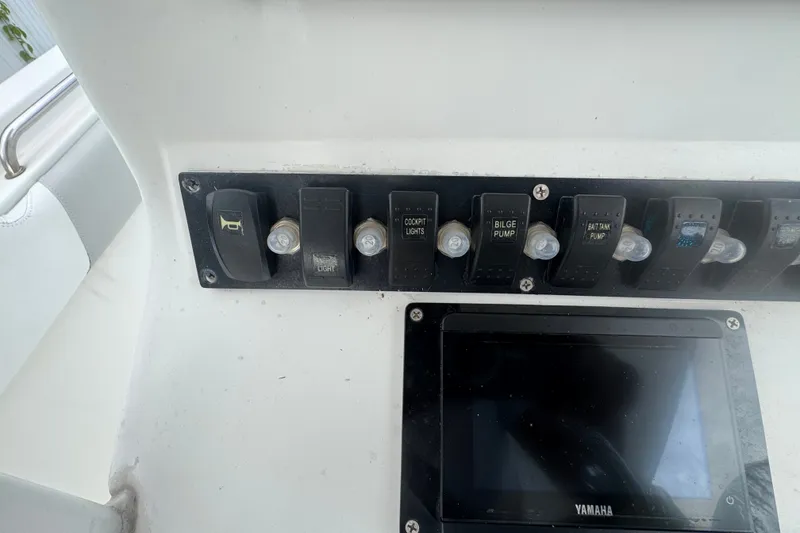 Slide: The Image of Control panel of a 2015 Sea Hunt Ultra 235SE boat with switches and display. - 21