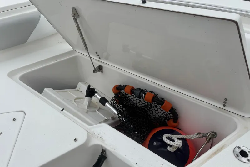 Slide: The Image of Open storage compartment on 2015 Sea Hunt Ultra 235SE boat with marine equipment. - 35