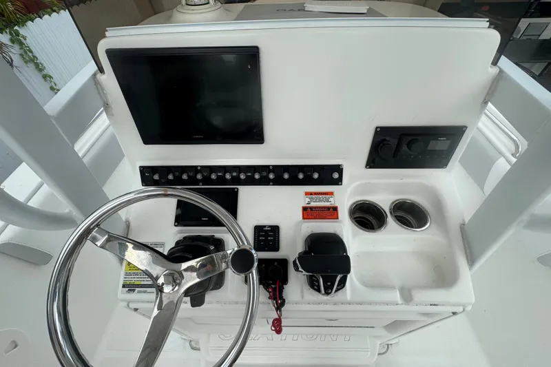 Slide: The Image of 2015 Sea Hunt Ultra 235SE boat dashboard with steering wheel and control panel. - 19