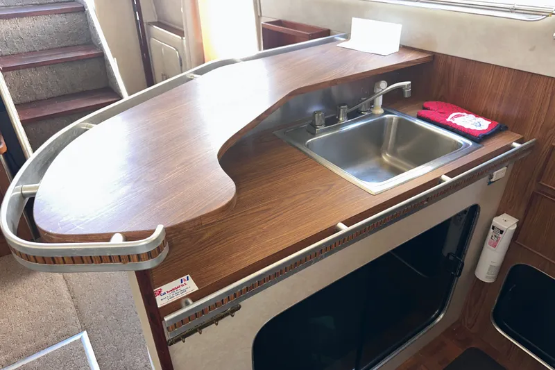 Slide: The Image of 1984 Chris-Craft 381 Catalina kitchen area with wooden countertop and stainless steel sink. - 20
