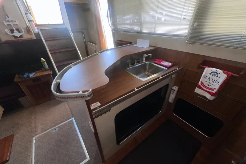 Slide: The Image of 1984 Chris-Craft 381 Catalina interior with kitchen sink and nautical decor. - 19