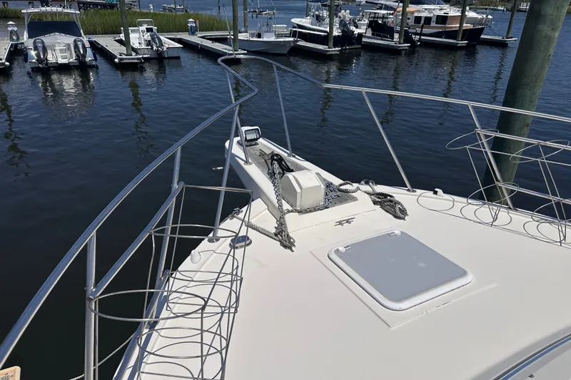 Slide: The Image of 1984 Chris-Craft 381 Catalina yacht bow at marina, showcasing anchor and railing. - 5
