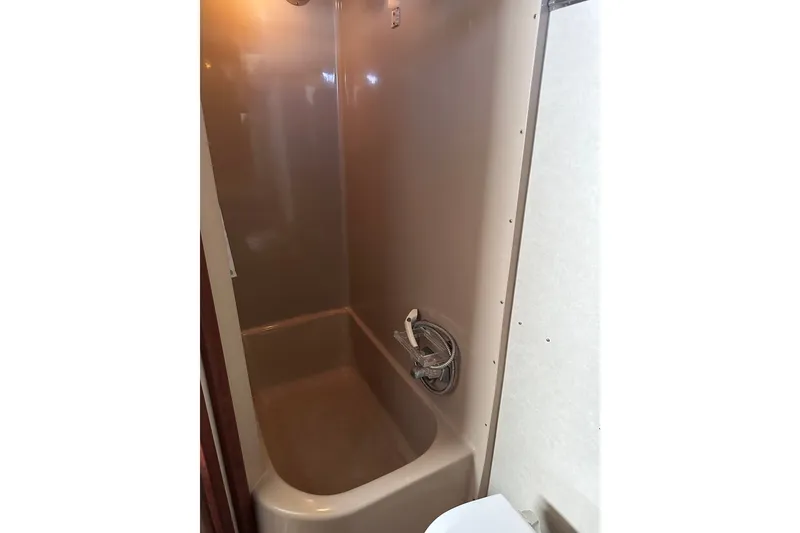 Slide: The Image of Shower area inside 1984 Chris-Craft 381 Catalina boat, featuring beige walls and fixtures. - 35