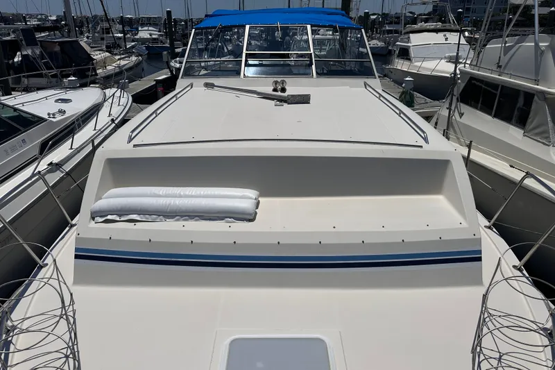 Slide: The Image of 1984 Chris-Craft 381 Catalina yacht docked at marina, featuring spacious deck and blue accents. - 6