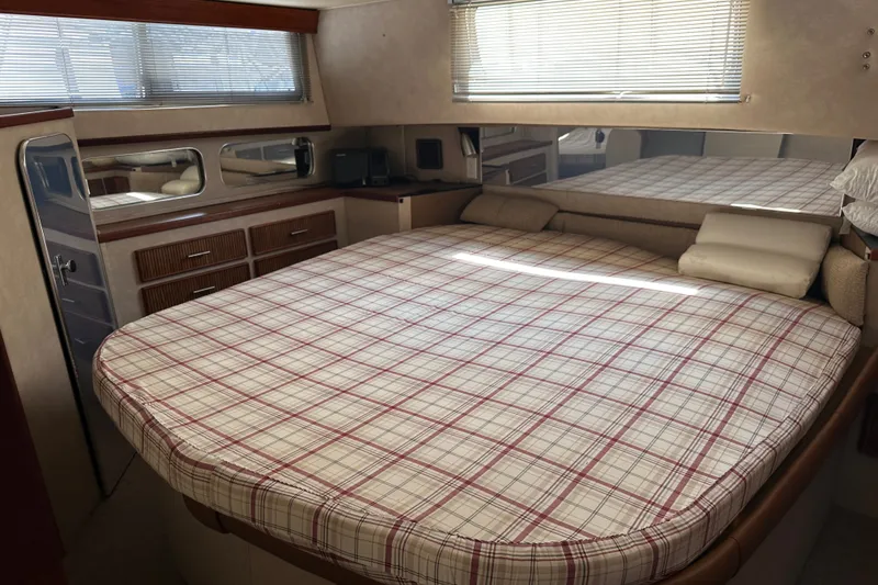 Slide: The Image of 1984 Chris-Craft 381 Catalina cabin interior with plaid bedspread and wooden cabinetry. - 30