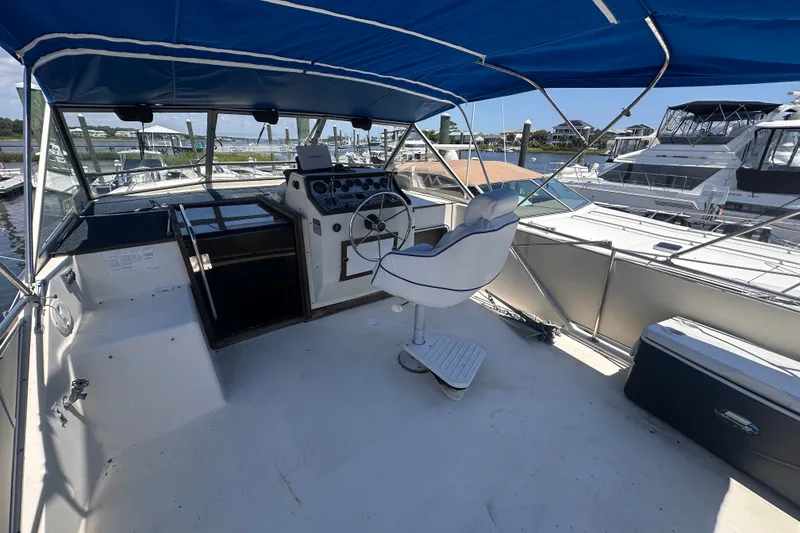 Slide: The Image of 1984 Chris-Craft 381 Catalina boat helm with blue canopy and marina view. - 10