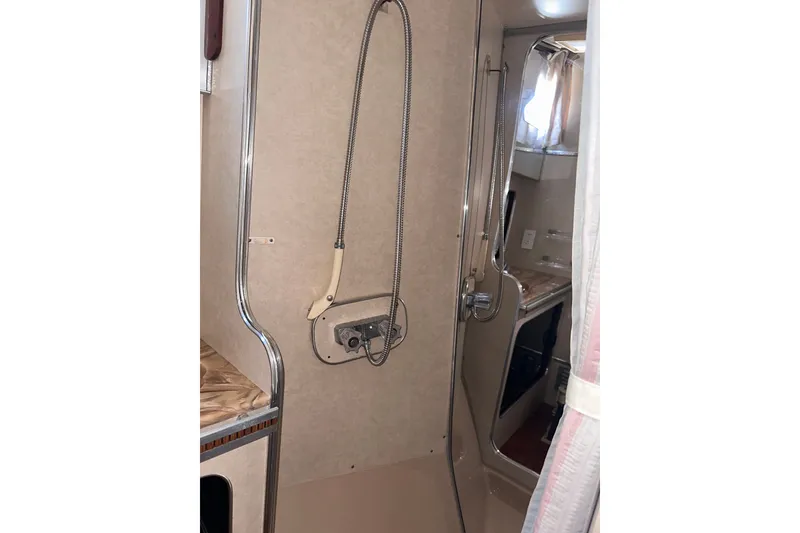 Slide: The Image of Shower area inside 1984 Chris-Craft 381 Catalina yacht, featuring beige interior and chrome fixtures. - 25
