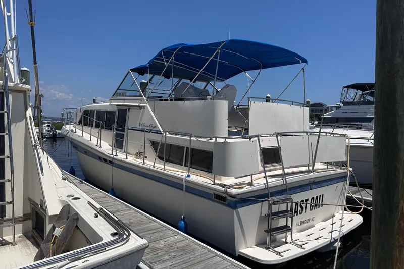 The Image of 1984 Chris-Craft 381 Catalina yacht docked with blue canopy under clear sky. - 1
