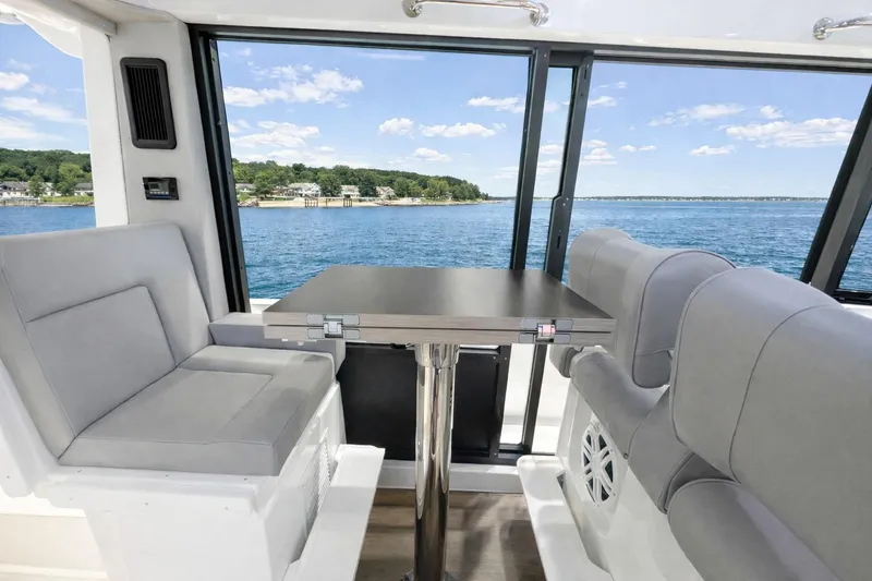 Slide: The Image of Interior view of 2026 Cruisers Yachts 38 VTR, featuring seating and table with scenic water view. - 6