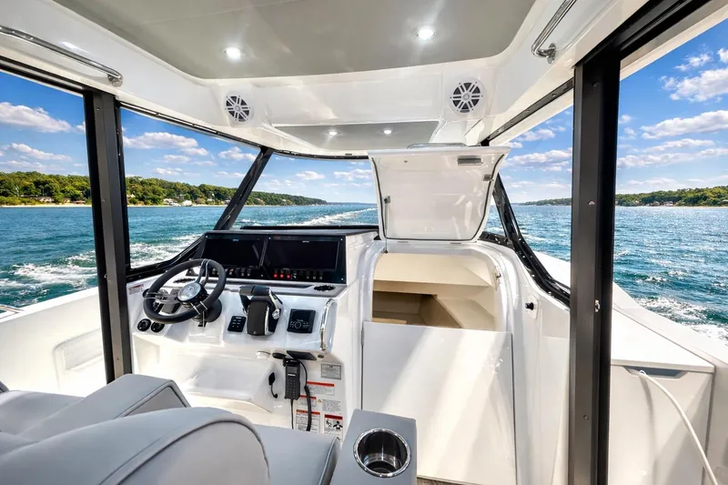 Slide: The Image of 2026 Cruisers Yachts 38 VTR helm with modern controls, overlooking scenic waterway. - 10