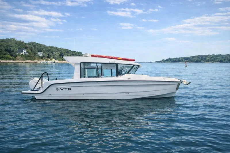 The Image of 2026 Cruisers Yachts 38 VTR on serene lake with lush shoreline. - 0