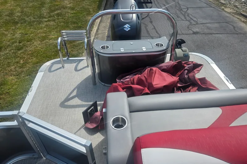 Slide: The Image of 2024 Avalon LSZ Cruise Bench pontoon boat with red upholstery and sleek design. - 15