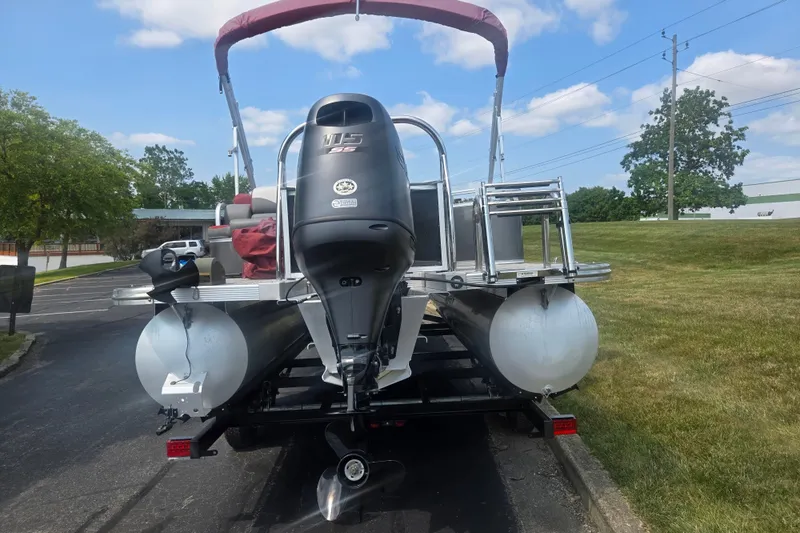 Slide: The Image of 2024 Avalon LSZ Cruise Bench pontoon boat with outboard motor on trailer. - 2