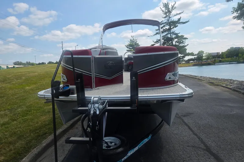 Slide: The Image of 2024 Avalon LSZ Cruise Bench pontoon boat on trailer by a lakeside. - 6