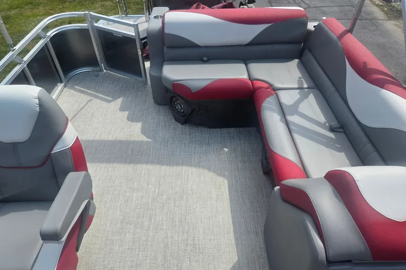 Slide: The Image of 2024 Avalon LSZ Cruise Bench interior with red and gray seating on a pontoon boat. - 14