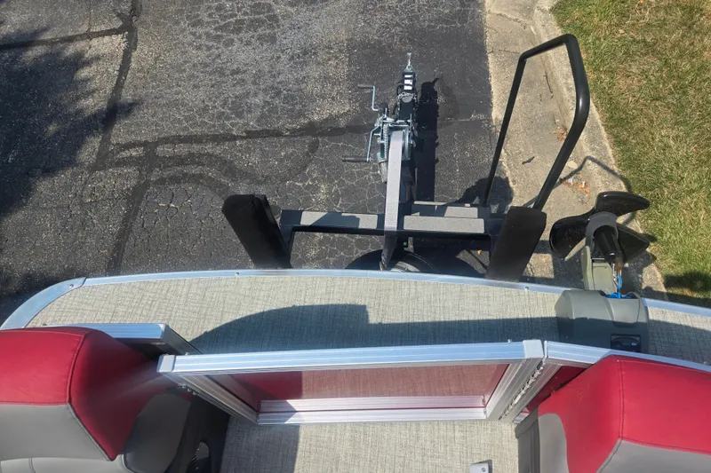 Slide: The Image of 2024 Avalon LSZ Cruise Bench boat on trailer, viewed from above, with red seating. - 24