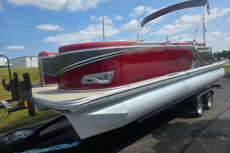 Slide: The Image of 2024 Avalon LSZ Cruise Bench pontoon boat on trailer, red and silver design. - 5