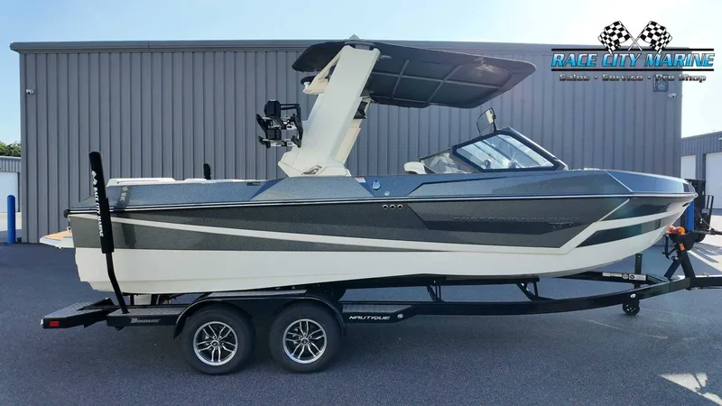 The Image of The image shows a modern motorboat on a trailer in front of a building. - 1