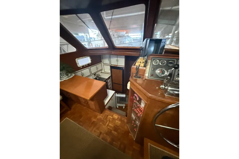 Slide: The Image of 1983 Ocean Alexander 43 Flush Aft Deck interior with helm, wood finish, and navigation instruments. - 14