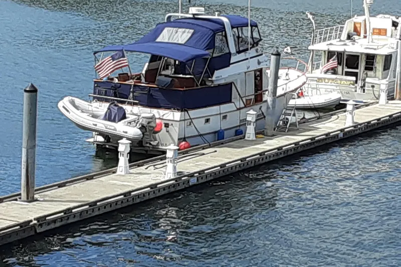 Slide: The Image of 1983 Ocean Alexander 43 Flush Aft Deck yacht docked with American flag. - 1