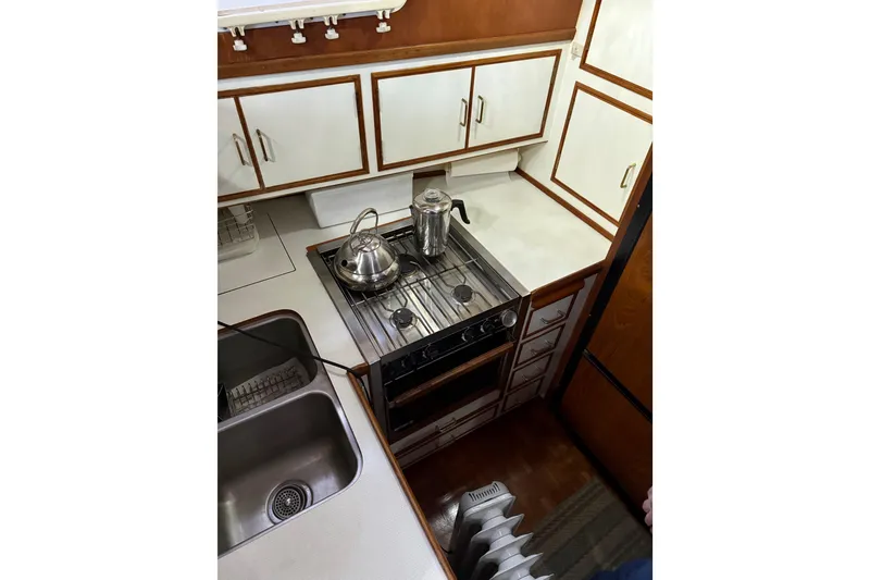 Slide: The Image of 1983 Ocean Alexander 43 Flush Aft Deck yacht kitchen with stove, sink, and cabinets. - 10