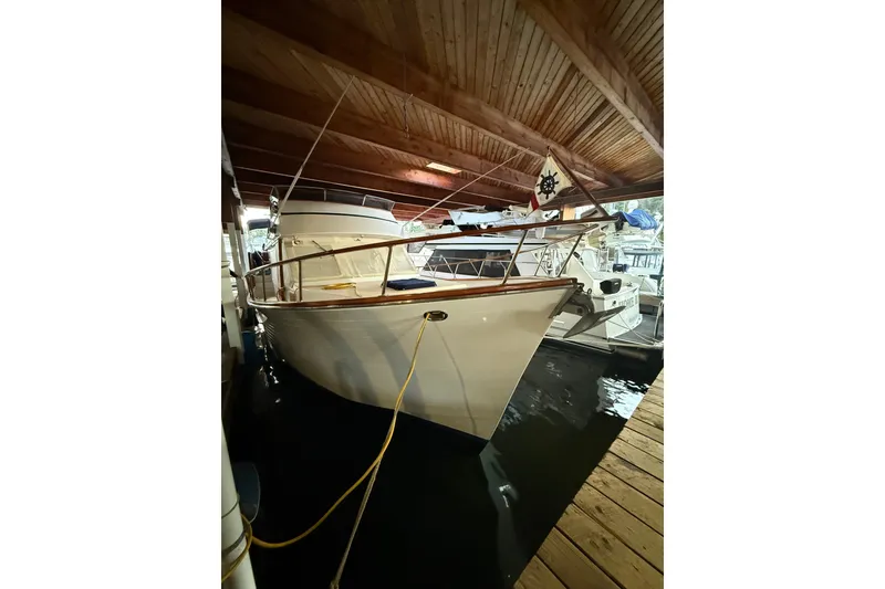 Slide: The Image of 1983 Ocean Alexander 43 Flush Aft Deck yacht docked under wooden roof. - 4