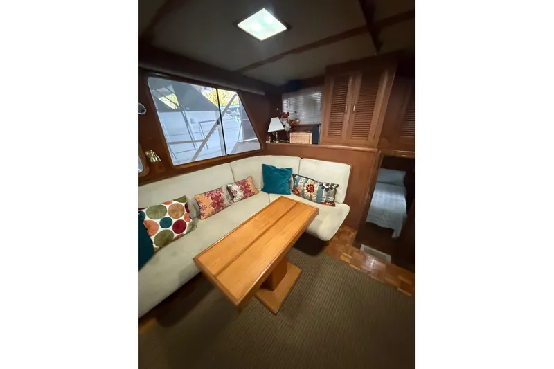 Slide: The Image of Interior of 1983 Ocean Alexander 43 Flush Aft Deck with cozy seating and colorful pillows. - 8